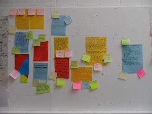 Colourful paper posts and comments on a pin board.
