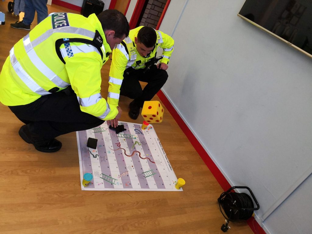 Two members of the police playing a snakes and ladders game