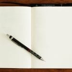 Pen, on an open, blank notebook