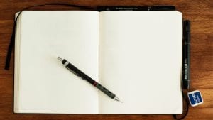 Pen, on an open, blank notebook